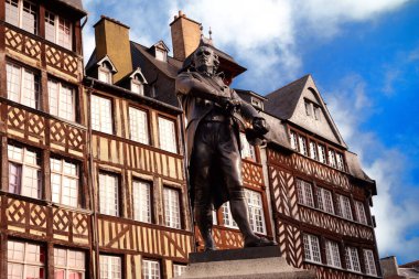 Jean Leperdit 'in heykeli Brittany, Rennes' deki yarım keresteli evlerin önünde. 