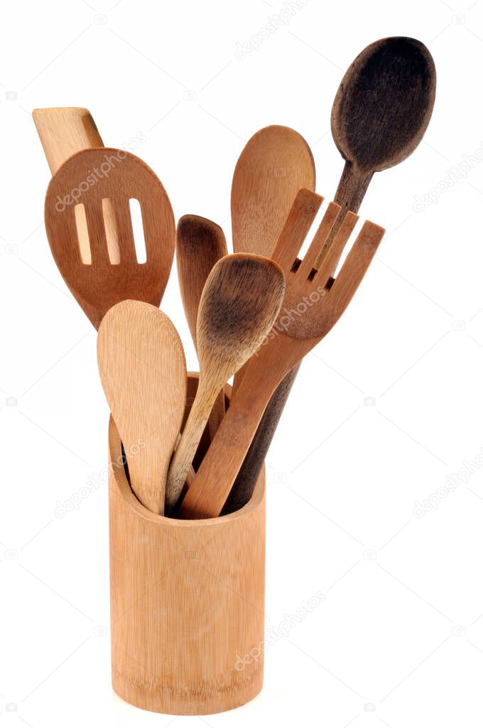 Wooden cutlery in a pot close-up on white background 