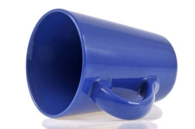 Mavi fincan beyaz arka plana yakın plan döküldü 