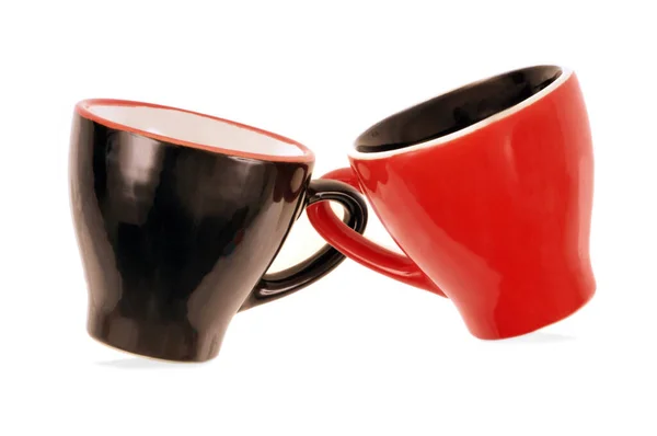 一个红色杯子和一个黑色杯子在白色背景上的特写 — 图库照片