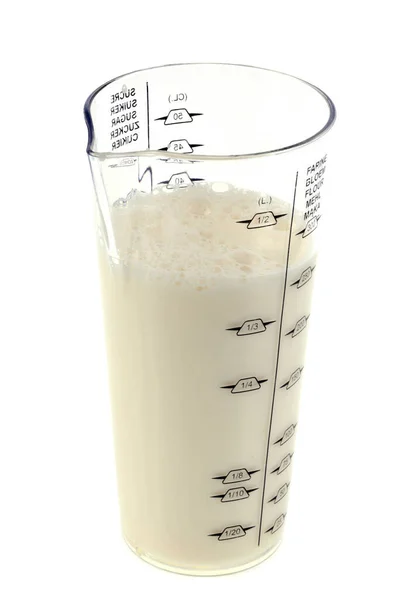 在白色背景下测量装满牛奶的杯子 — 图库照片