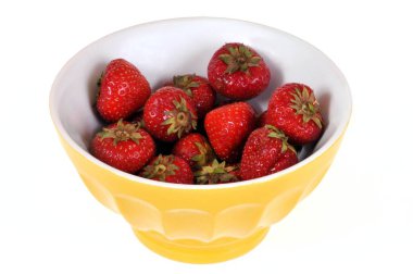 Siyah arka planda bir kase çilek. 