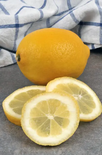 Zitronenscheiben Und Ganze Zitrone Nahaufnahme Auf Grauem Hintergrund — Stockfoto
