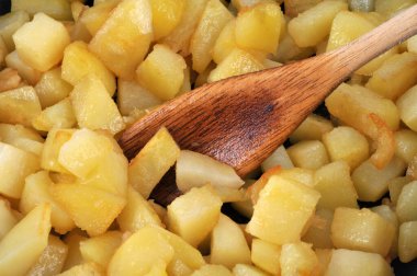 Tahta kaşıkla küp küp kesilmiş patatesler. 