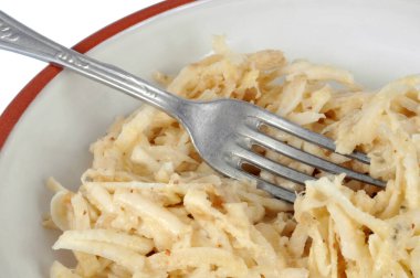 Beyaz arka planda çatallı rendelenmiş kereviz tabakası