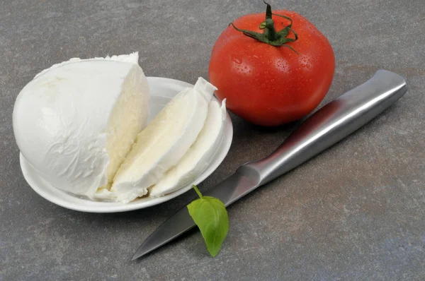 Mozzarella Mit Basilikum Untertasse Nahaufnahme Neben Messer Und Tomate — Stockfoto