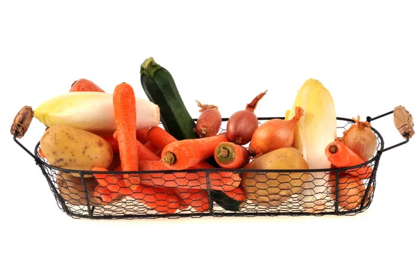 Assortment of autumn vegetables in a steel basket close-up on a white background