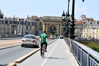 Bordeaux 'daki taş köprüde bisikletçi. 