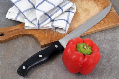 Kesme tahtası ve yakın plan bıçaklı kırmızı dolma biber. 