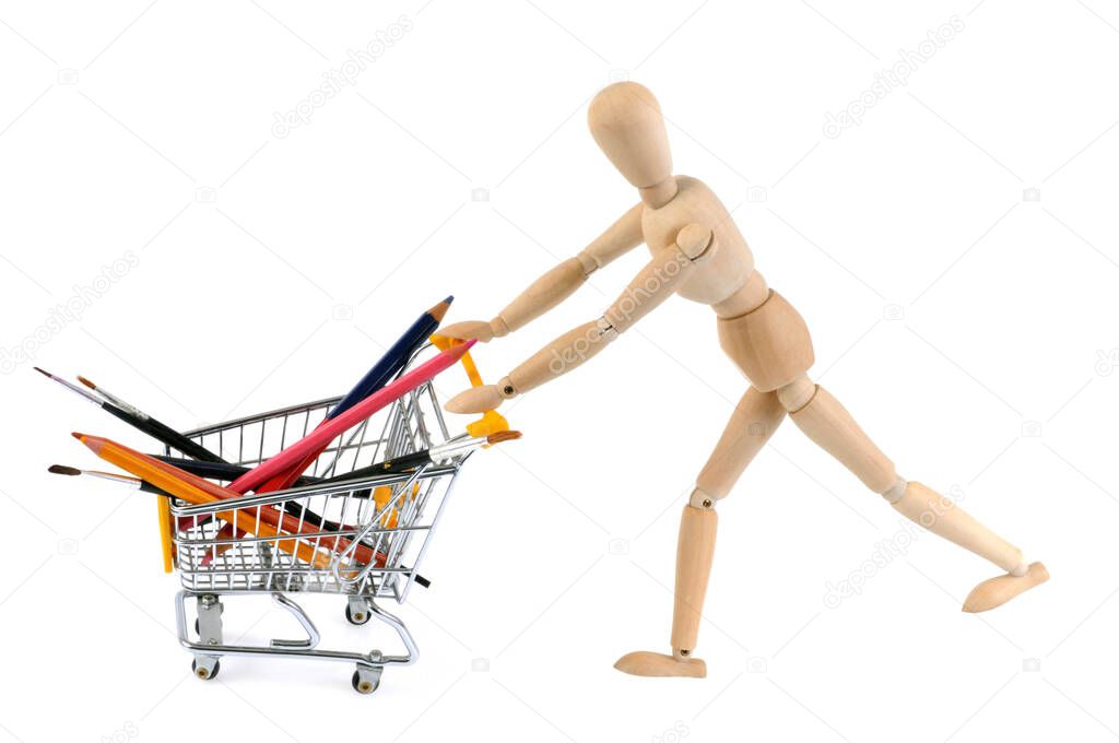 Concept of shopping for school supplies with a wooden mannequin pushing a shopping cart on a white background