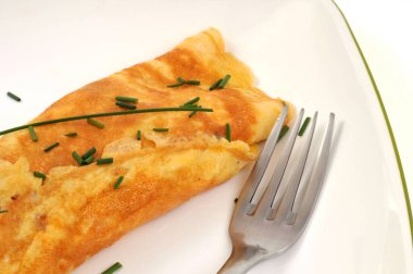 Beyaz arka planda tabakta servis edilen bitkisel omlet. 