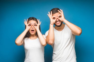 Mavi arka planda mutlu genç bir çiftin portresi