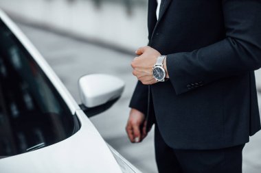 Yeni beyaz arabanın yanındaki yakışıklı genç işadamı, seçici odaklı.