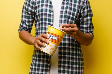 Sarı arka planda patlamış mısırlı adam manzarası