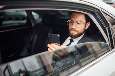 Yakışıklı genç iş adamı araba kullanıyor, seçici odaklı.