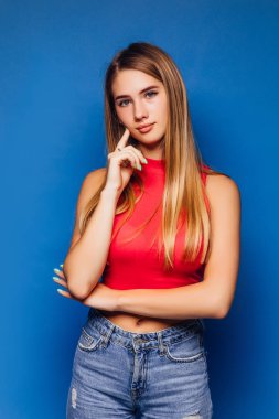 Genç ve güzel bir kadın mavi arka planda poz veriyor