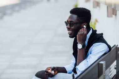 Sokakta gülümseyen mutlu genç adam, seçici odaklanma 