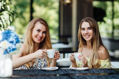 Güzel anne ve kız birlikte kahve içiyorlar, seçici bir şekilde odaklanıyorlar.