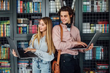 Üniversite kütüphanesinde iki öğrenci, seçici odaklanma