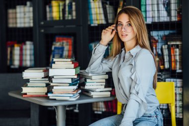 Kütüphanedeki güzel genç bayan öğrenci. 