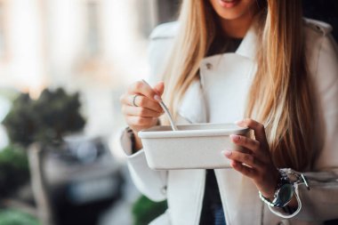 Kız beslenme çantasıyla kahvaltı yapıyor. 