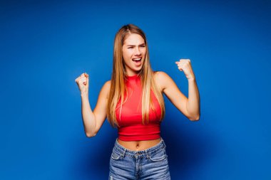 Genç ve güzel bir kadın mavi arka planda poz veriyor