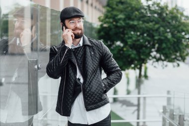 Açık havada telefon kullanan şık bir adam, seçici odaklanma.