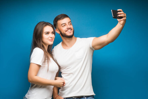 Portrait of happy young couple against blue background