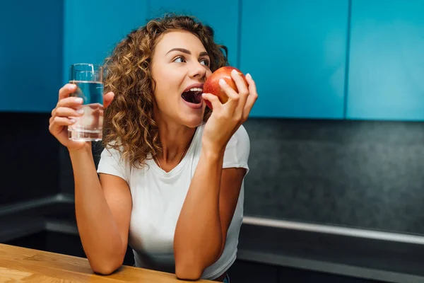 饥饿的女人在现代厨房吃饭 有选择的焦点 — 图库照片