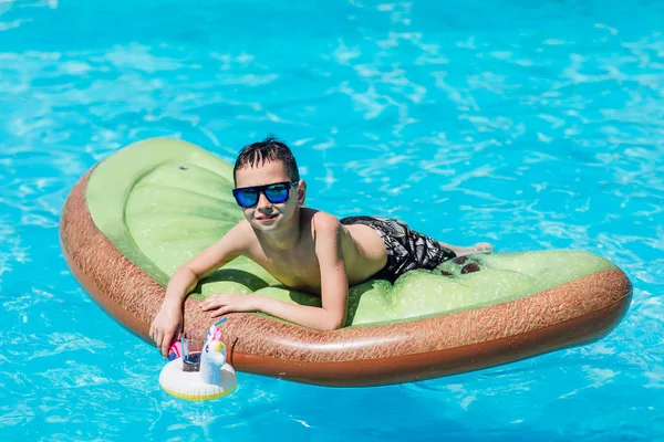 可爱的小男孩躺在夏天的游泳池里 — 图库照片