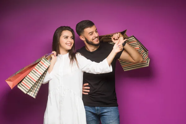 Couple with luxury bags on violet background
