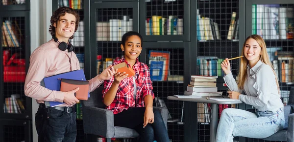 Troje Szczęśliwych Studentów Uczących Się Bibliotece Wybiórcze Skupienie — Zdjęcie stockowe