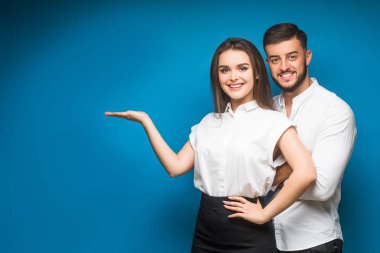 Mavi arka planda mutlu genç bir çiftin portresi