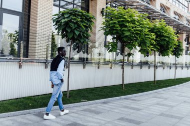 Sokakta gülümseyen mutlu genç adam, seçici odaklanma 