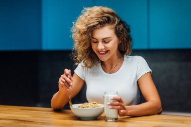 Modern mutfakta yemek yiyen aç kadın, seçici odaklanma.