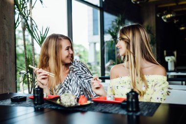 Mutlu anne ve kız yazın terasta yemek yiyor. 