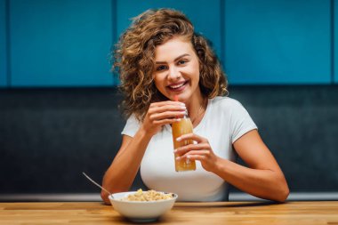 Modern mutfakta yemek yiyen aç kadın, seçici odaklanma.