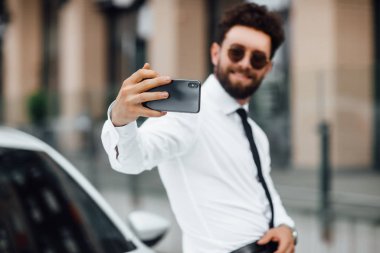 Açık havada telefon kullanan şık bir adam, seçici odaklanma.