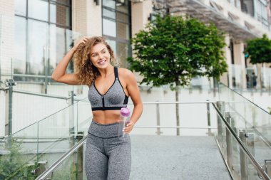 Spor kıyafetli güzel bir kadın dışarıda egzersiz yapıyor.