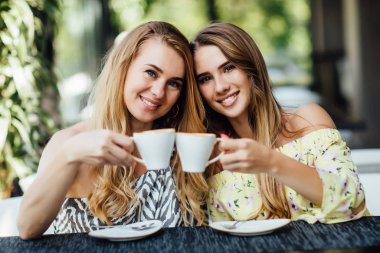 Güzel anne ve kız birlikte kahve içiyorlar, seçici bir şekilde odaklanıyorlar.