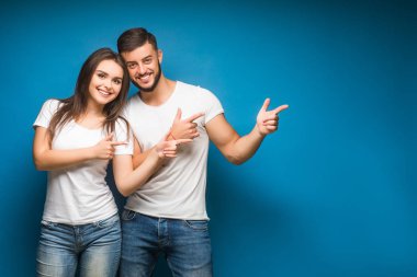 Mavi arka planda mutlu genç bir çiftin portresi