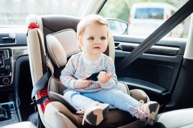 Otomobil koltuğunda oturan sevimli küçük çocuk, seçici odaklı.