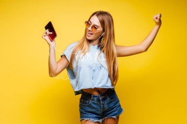 Sarı arka planda poz veren çekici kadın.