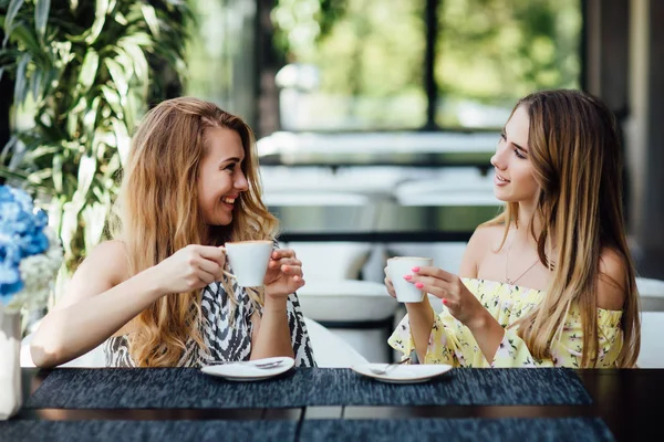 beautiful mother and daughter drinking coffee together, selective focus