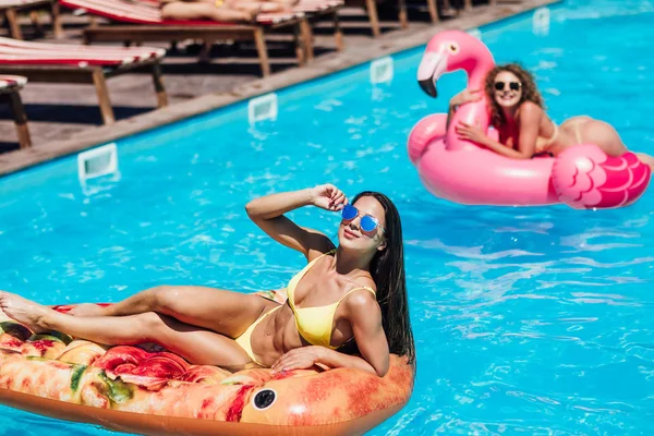 Hermosas Mujeres Jóvenes Traje Baño Sonriendo Mientras Flotan Piscina —  Fotos de Stock