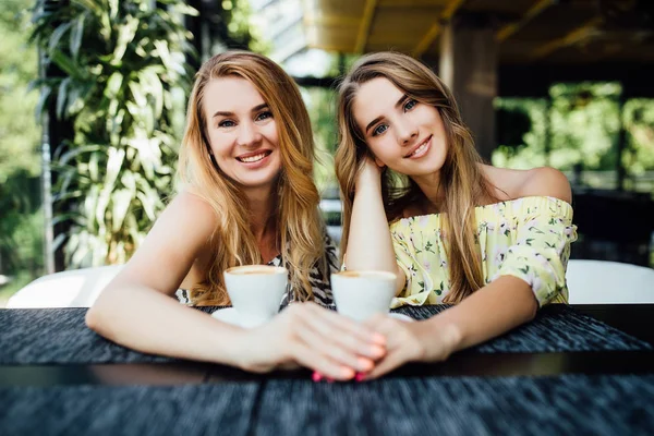 beautiful mother and daughter drinking coffee together, selective focus