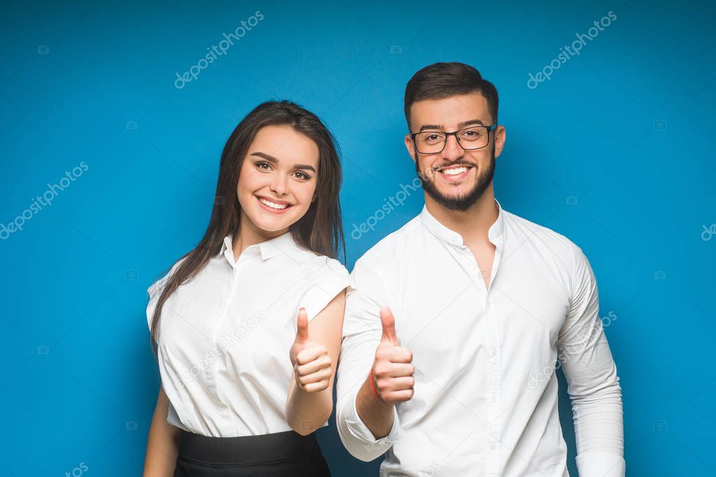 Portrait of happy young couple against blue background