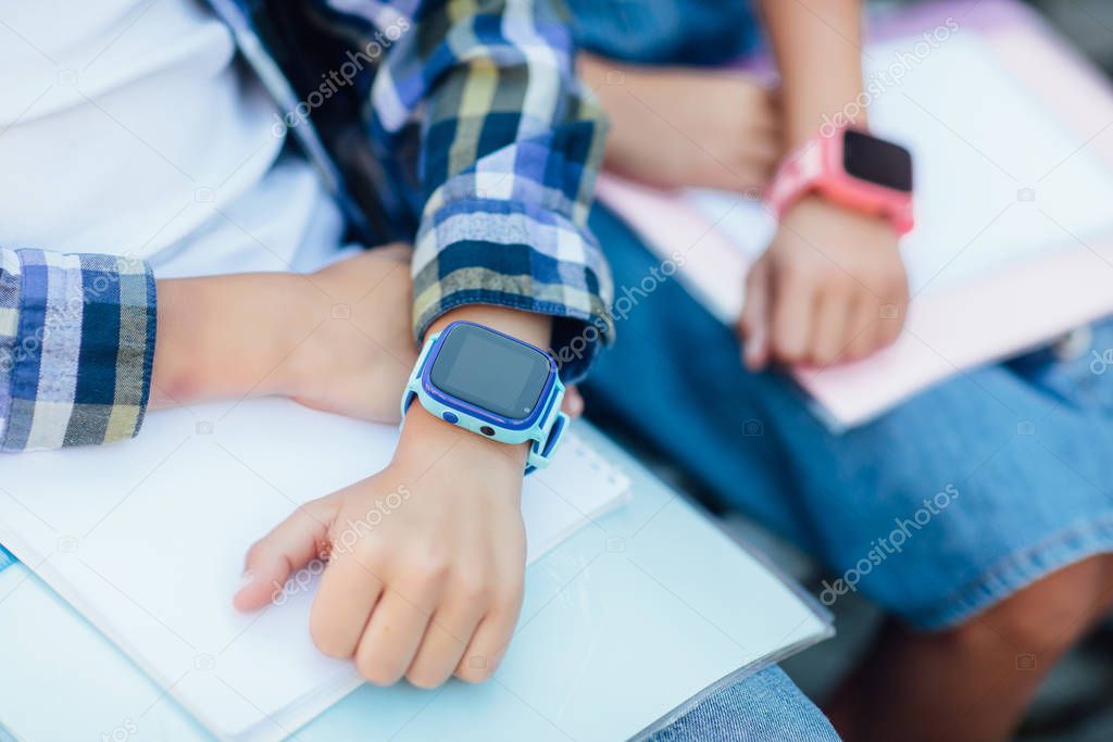 Close-up of children using smartwatches, selective focus