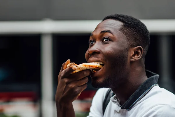 Young Man Eats Piece Appetizing Pizza Hungry Guy Holds Piece — Stock Photo, Image