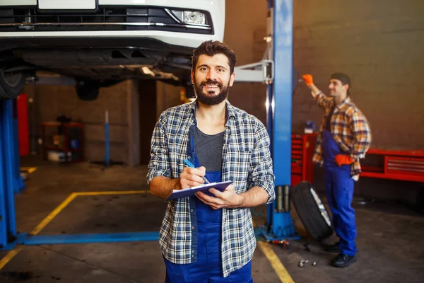 Πορτρέτο Των Νέων Automechanic Γραφή Στο Πρόχειρο Και Κοιτάζοντας Την — Φωτογραφία Αρχείου